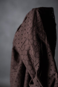 a dark rich purple eyelet embroidered cotton fabric