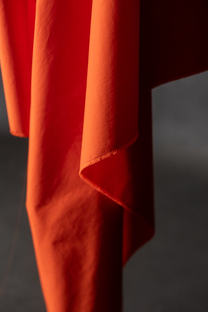 An orange red crisp cotton poplin fabric